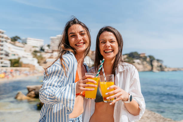 Twee vrouwen genieten van zon en cocktails aan het strand